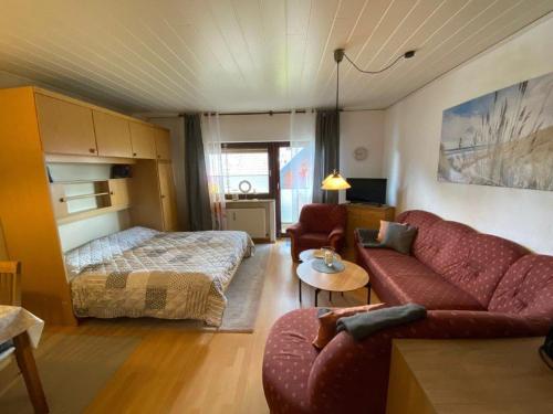 a living room with a couch and a bed at Ferienwohnung "Strandoase" in Burhave