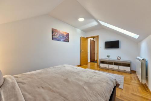 a bedroom with a bed and a flat screen tv at CENTRUM APARTMENT Zlatibor in Zlatibor