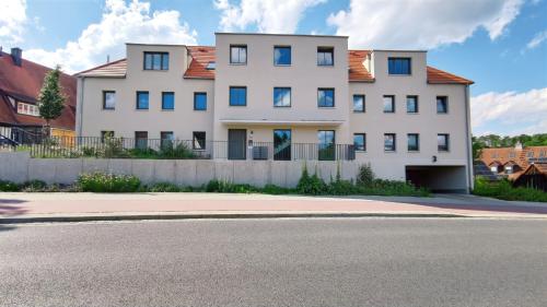 a white house with a fence and a street at CityVibe Apartment für bis zu 4 in Erlangen