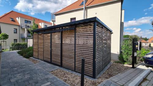 a wooden privacy fence in front of a house at CityVibe Apartment für bis zu 4 in Erlangen