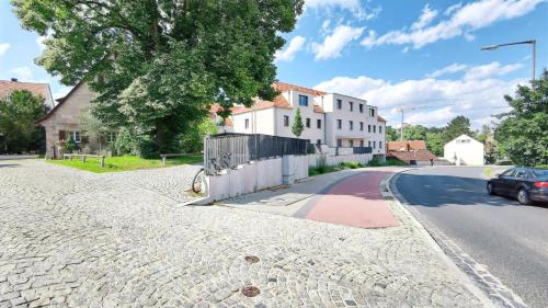 a street with a house and a car on the road at CityVibe Apartment für bis zu 4 in Erlangen