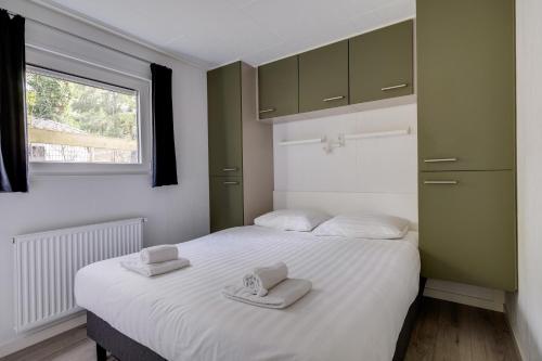 a bedroom with two beds with towels on them at Heerlijk huisje op de Veluwe in Hoenderloo