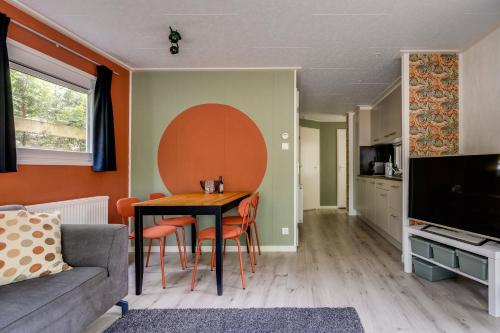 a living room with a table and a couch at Heerlijk huisje op de Veluwe in Hoenderloo
