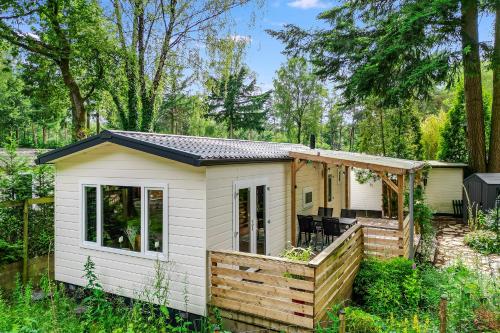 a tiny house in the woods with a deck at Heerlijk huisje op de Veluwe in Hoenderloo