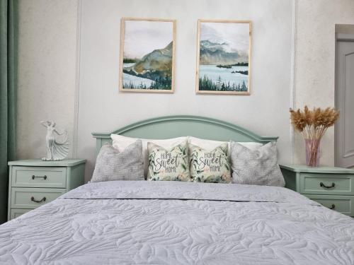 a bedroom with a bed with three pictures on the wall at Идеальная 4-х комн, с домашним уютом и простором in Kostanay