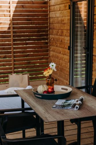 a wooden table with a bowl of fruit on it at Slow Village Anduze - Cévennes in Corbés
