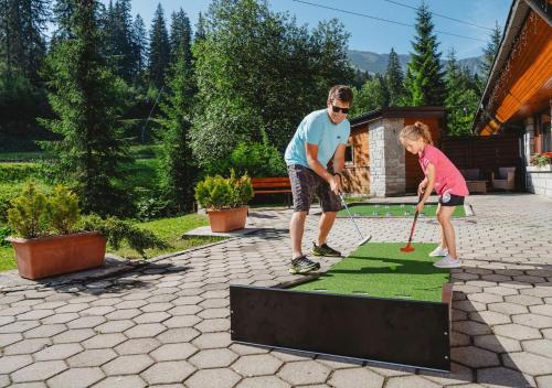 a man and a little girl playing a game of golf at Hotel Grand Jasná in Demanovska Dolina