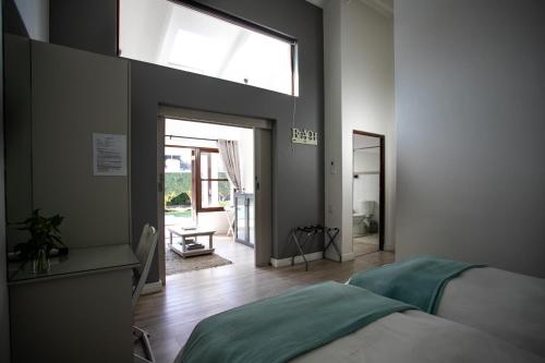 a bedroom with a bed and a large window at Sixteen Guesthouse on Main in Hermanus