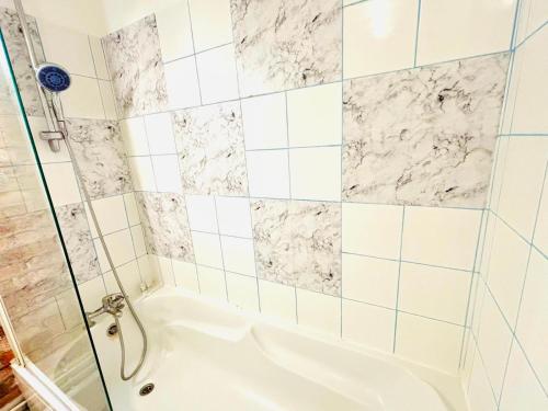 een badkamer met een douche en een wit bad bij Appartement rue Lecourbe in Parijs