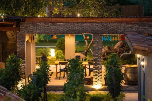 a patio with a table and a bench at night at Vineyard Hotel & Winery in Napareuli