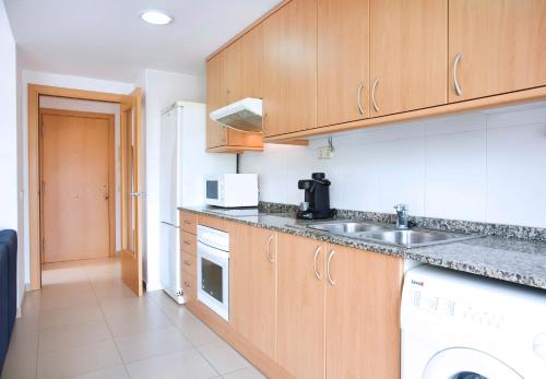 eine Küche mit Spüle und Geschirrspüler in der Unterkunft ENJOY your HOLIDAYS with us !!, TERRACE 25m2 - Apartment 65m2 3 Bedrooms, Capacity 4-6pers, WIFI, IDEAL to DIGITAL NOMAD Beach 5min walking, 4 Pools, Parking Opt, Air Conditioning in Lloret de Mar