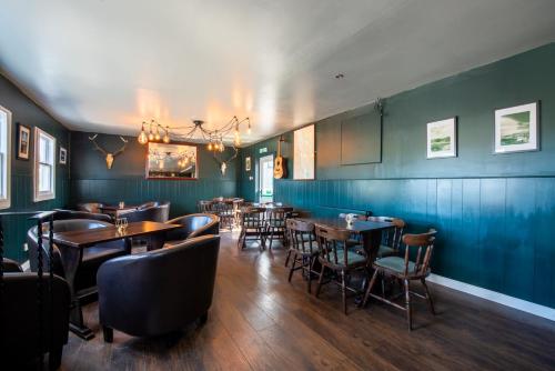 a dining room with wooden tables and chairs at Aultbea Hotel in Achnasheen