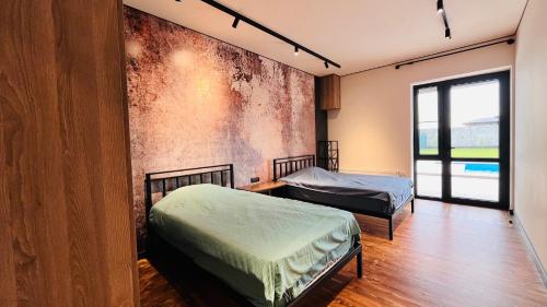 a room with two beds and a wall with a mural at Pool House in Yerevan