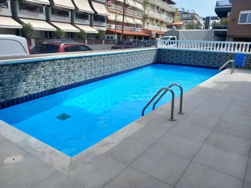 a swimming pool with blue water in a building at Bella Luxury Suite II in Paralia Katerinis