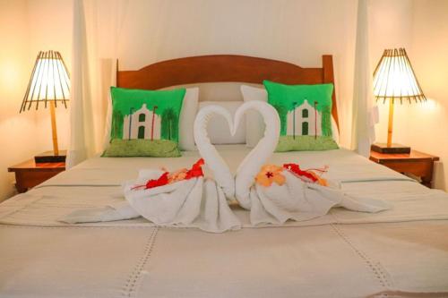 two swans made out of towels on a bed at Pousada Campestre in Trancoso