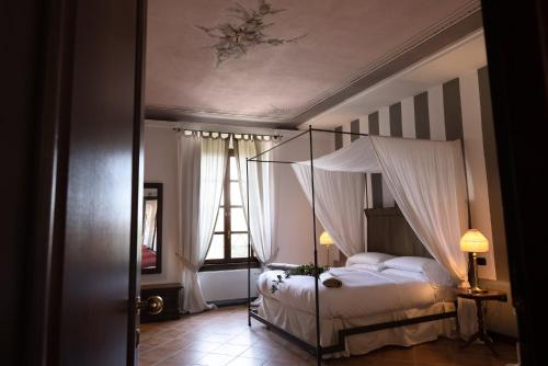 a bedroom with a canopy bed and a window at Al Castello Resort in Sillavengo