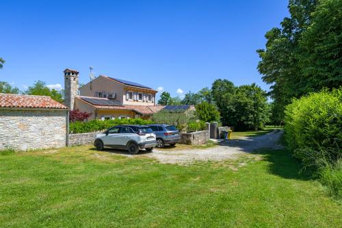 two cars parked in a yard in front of a house at Villa Lipa in Krnica