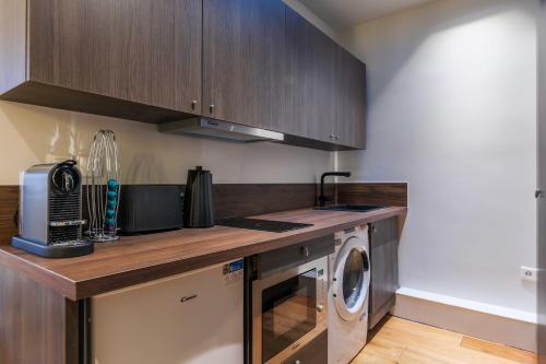 une cuisine avec une machine à laver et un lave-linge dans l'établissement Chic studio - 2P - Arc de Triomphe, à Paris
