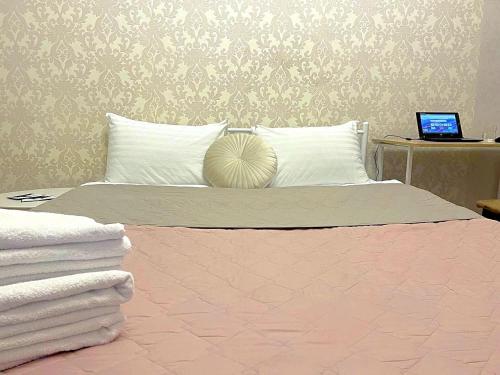 a bedroom with a bed with a laptop on a table at Лавандовий світанок Однокімнатна квартира біля ЦУМу в центрі Полтави Мережа AlexApartments Документи для відряджень Безконтатне заселення 24-7 in Poltava