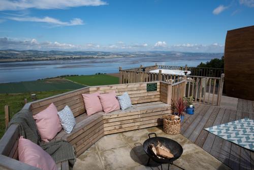 a patio with a couch and a fire pit at Luxurious Snug with hottub which sleeps-2 in Fife in Newburgh