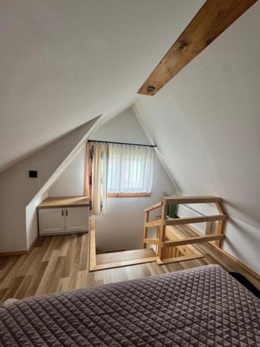 a attic bedroom with a bed and a staircase at U Młynorza Jacuzzi ogrodowe całoroczne in Suche