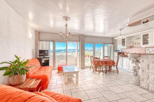 un salon avec un canapé orange et une table dans l'établissement 2 PIECEs BALCON VUE IMPRENABLE MER---VILLE---MONTAGNE, à Nice