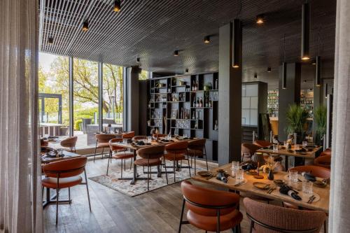 a restaurant with tables and chairs and a book shelf at Hedon Spa & Hotel in Pärnu