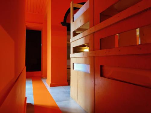 an orange room with ajar doors and a hallway at Out of the Blue in Ponta Delgada