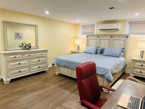 a bedroom with a bed and a red chair at Luxurious Basement Retreat in Charlottetown