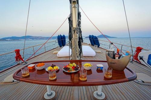 una mesa en la cubierta de un barco con comida. en Luxury Hotel Boat in Bodrum Marina, en Bodrum City