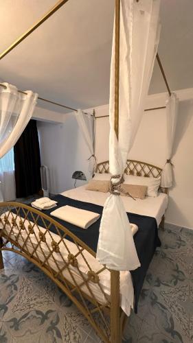 a bedroom with a canopy bed with white curtains at Forest house in Eforie Nord