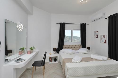 a bedroom with two beds and a desk and a window at Villa Mirage Skopelos in Skopelos Town