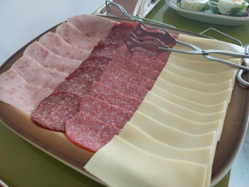 a platter with slices of meat on a table at Hotel Asila in Karlovy Vary