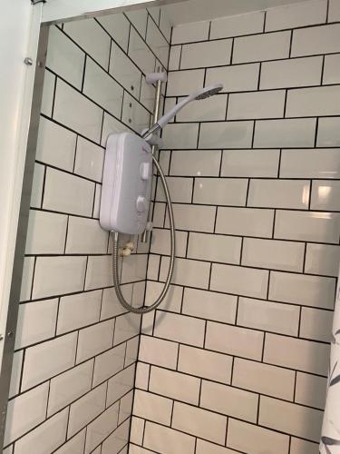 un bagno con doccia e pareti bianche piastrellate di Hillside Launceston Cornwall a Launceston
