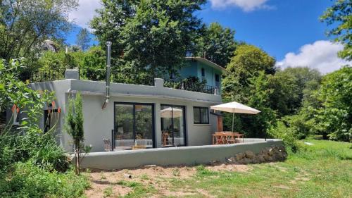 a small white house with an umbrella in a yard at Quinta da Lontra in Tábua