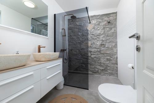 a bathroom with a stone shower and a sink at Villa Angelica in Lakmartin