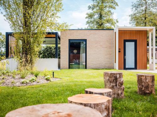 a house with tree stumps in the yard at Calming Hideaway in Veluwe in Voorthuizen