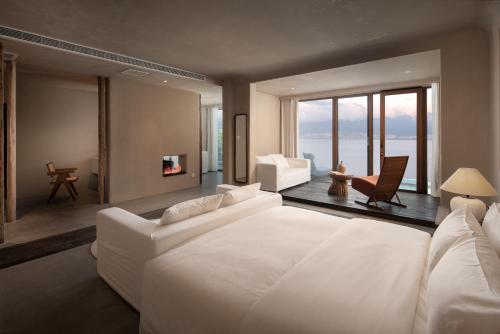 a bedroom with a white bed and a living room at 慢境Slow Land半山海景花园酒店 in Dali
