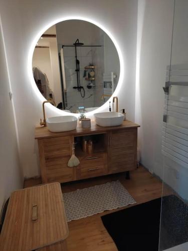 une salle de bain avec deux lavabos et un grand miroir dans l'établissement Maison de ville, à Romans-sur-Isère