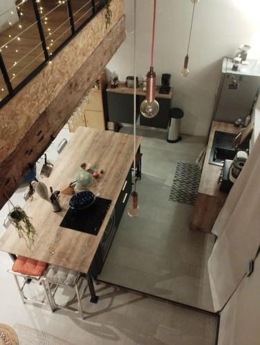 - une vue de tête sur une cuisine avec une table en bois dans l'établissement Maison de ville, à Romans-sur-Isère