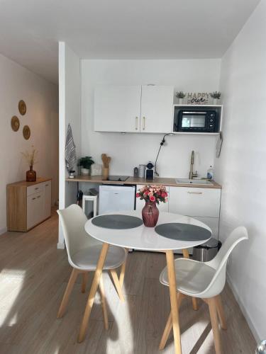une cuisine avec une table et des chaises dans une cuisine dans l'établissement Cozy Studio Heart of La Défense - 10 min to Paris, à Courbevoie