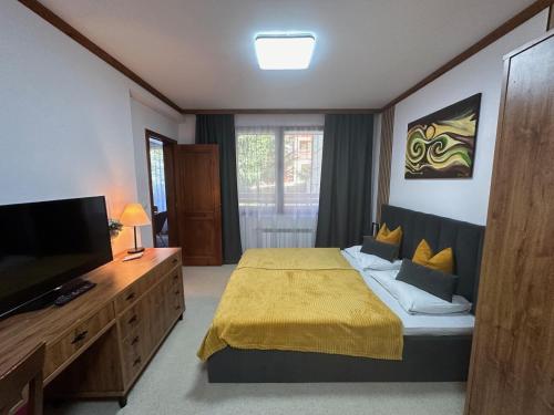 a bedroom with a bed and a flat screen tv at Family Luxury Private Apartment for 4 max 6 people in 4 star SPA Resort St Ivan Rilski, Bansko in Bansko