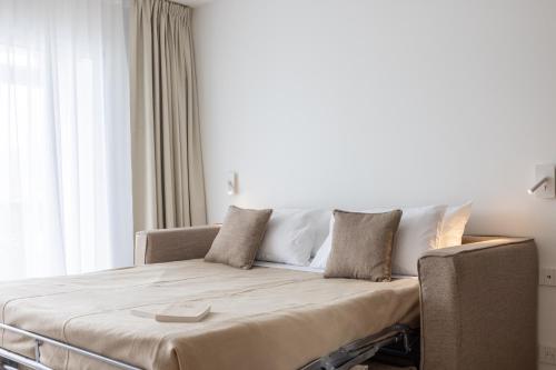 a couch in a room with a large window at Résidence Ibaïa - Piscine & Spa in Hendaye