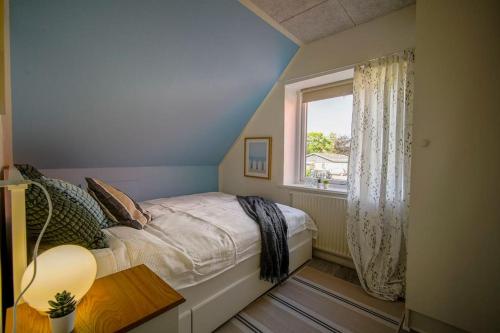a bedroom with a bed and a window at FeWo Sjælland B in Sindal