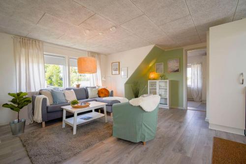 a living room with a couch and a table at FeWo Sjælland B in Sindal