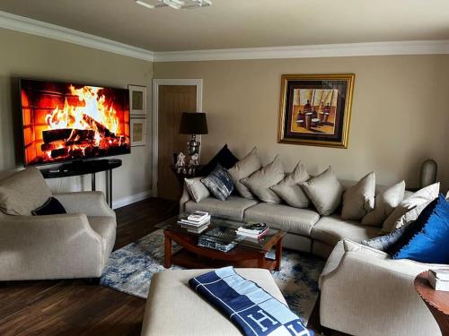 a living room with a couch and a fireplace at Sarsa Cottage Ballynahinch in Ballynahinch