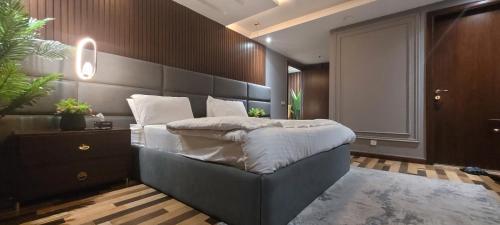 a bedroom with a large bed in a room at Goldcrest Apartments in Lahore