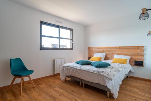 Clohars-CarnoëtにあるVilla des îles - A 350m de la plageのベッドルーム1室(ベッド1台、青い椅子付)