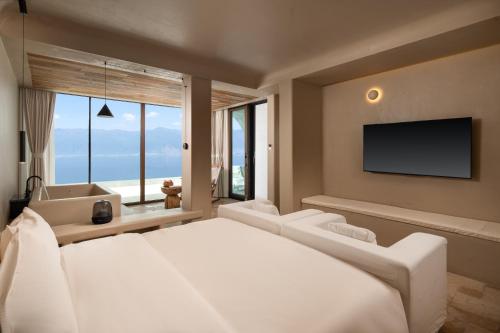 a bedroom with a large bed and a television at 慢境Slow Land半山海景花园酒店 in Dali