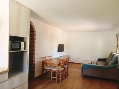 a living room with a table and a couch at Apartamento LUZ E in Bolonia